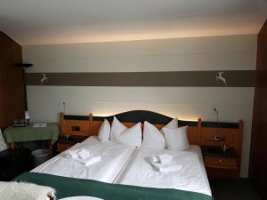 基姆湖畔贝尔瑙Hotel Jägerhof garni的一间卧室配有一张带白色毛巾的床