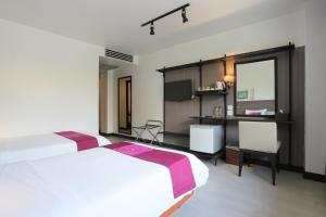 清莱The Mantrini Chiang Rai-SHA Extra Plus的酒店客房配有两张床和一张书桌