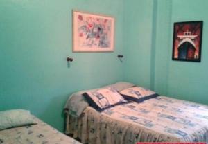 TucacasCosta Grande的一间卧室设有两张单人床和蓝色的墙壁。