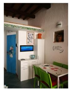 Isola del GiglioLA PERLA的一间带桌子和绿色椅子的用餐室