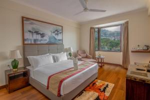 西姆拉Larisa Shimla的一间卧室设有一张大床和一个大窗户