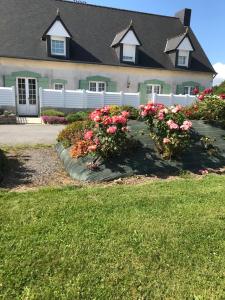普洛默迪耶尔恩梅内斯-霍姆住宿加早餐旅馆的院子前有粉红色花的房子