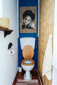 拉戈斯Olive Hostel Lagos的浴室设有卫生间,墙上挂着一幅画