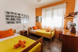 拉戈斯Olive Hostel Lagos的一间卧室设有两张床、一把椅子和一个窗户。