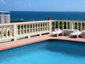 瓦利海洋露台公寓式酒店的一座背景海洋的游泳池