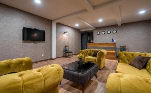 卡兹贝吉Travel Inn Kazbegi的客厅设有黄色沙发和平面电视。