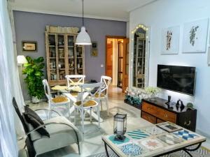 科尔多瓦Ziza的客厅配有桌椅和电视。