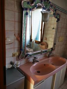 威尼斯丽都Cà ARIVANLIAL Venice villa apartament的浴室设有粉红色的盥洗盆和镜子
