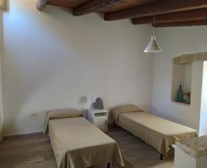 孔韦尔萨诺LA CASETTA 6058的白色墙壁客房的两张床