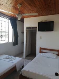 拉多拉达HOTEL LA QUINTA的一间卧室配有两张床和一台平面电视