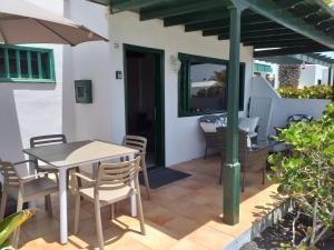 卡门港Bungalow DALAI - Pool view- Good wifi的庭院配有桌椅和遮阳伞。