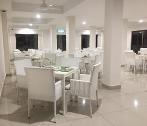 珍拉丁Royale Chulan Cherating Chalet的用餐室配有白色的桌子和白色的椅子