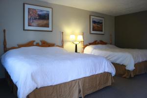 克拉马斯福尔斯玛夫里克汽车旅馆的配有白色床单的酒店客房内的两张床