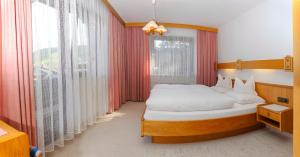 蒂罗尔-泽费尔德兰德海大公寓的一间卧室设有一张床和一个大窗户