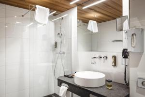 施伦斯阿卡缇弗阿尔彭罗斯温泉酒店的白色的浴室设有水槽和淋浴。