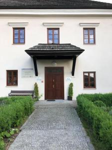 卡齐米日-多尔尼Zamkowa, Pokoje Gościnne的一间白色的房子,设有棕色的门和石头走道