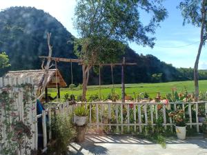 峰牙Phong Nha Rice Field Homestay的白色的围栏,花园,山丘,背景