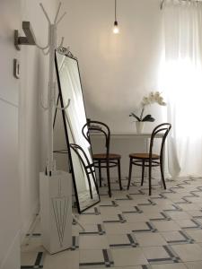 莱里奇Il Capitano的一间位于地板上的带椅子和镜子的用餐室
