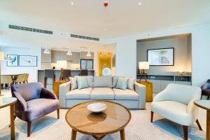 迪拜Vida Downtown Residences的客厅配有沙发、两把椅子和一张桌子