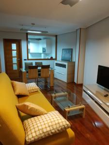 萨拉曼卡Apartamento Edificio Plaza Gran Vía的客厅配有黄色的沙发和桌子