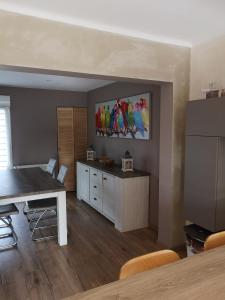 Montigny-lès-MetzDuplex cozy的厨房配有餐桌,墙上挂有绘画作品