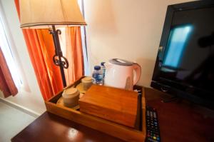 珀尼达岛Kampuak Cottages的床头柜、台灯和带电视的桌子
