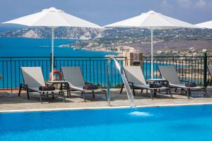 弗拉哈塔Antonia Hotel的一个带椅子和遮阳伞的游泳池以及大海