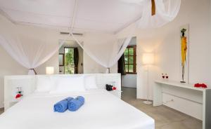 南威Sandies Baobab Beach Zanzibar的白色卧室配有白色的床和书桌