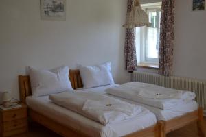 哈尔施塔特Gingin- rooms的卧室内的两张床,配有白色床单和枕头