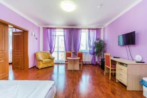 BlšanyHotel & Motorest V Údolí Zlatého potoka的一间卧室设有紫色的墙壁和一张桌子及椅子