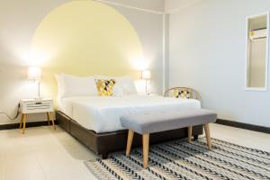 曼谷内维尤尊贵公寓：拉查达的一间卧室配有床、桌子和凳子