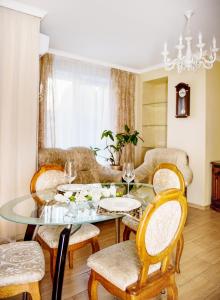 伊万诺-弗兰科夫斯克Apart Reserve Sloboda Suite的一间设有玻璃桌和椅子的用餐室