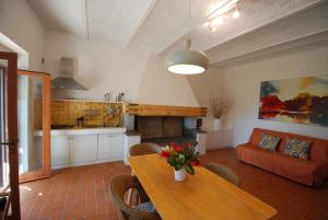 卡斯蒂里昂纳·德拉佩Agriturismo Podere il Leccio的厨房以及带桌子和沙发的客厅。
