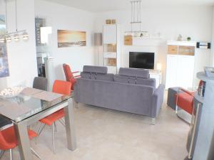 克伦胡森Sonnengarten 19的客厅配有灰色的沙发和橙色的椅子