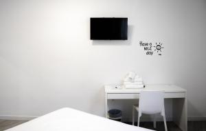 阿尔么丽亚BUTIK Almería Centro的一张白色的桌子,墙上配有电视