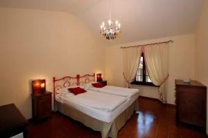勒威诺Il Giardino Segreto的一间卧室配有一张大床和一个吊灯。