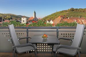SchelingenZieglers Ferienwohnungen的阳台上的桌椅和一碗水果