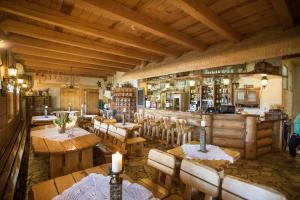 Kolesin塔贝斯卡客栈的一间带木桌椅的餐厅和一间酒吧