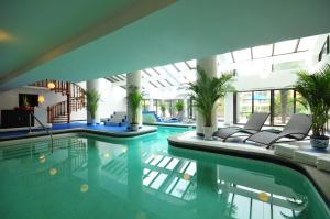 西安西安建国饭店的一座带椅子和植物的游泳池