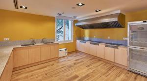 蒙塞拉特Alberg Abat Oliba的一间设有黄色墙壁和木地板的大厨房