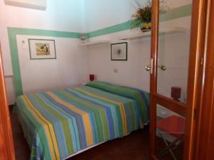 弗卡诺Villa Saracina的卧室配有带条纹床。