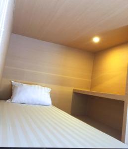 勒吉安XOXO Kuta Legian Hostel的一张带白色枕头的床
