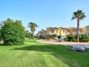 穆罗海滩BQ阿尔库迪亚太阳村酒店的棕榈树大院子,房屋