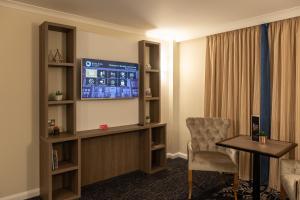 拉夫堡力推伯利法院休闲酒店的配有电视、桌子和椅子的房间