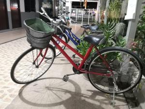 清迈Ban Maitree的一辆红色自行车,车上有一个篮子,停在人行道上