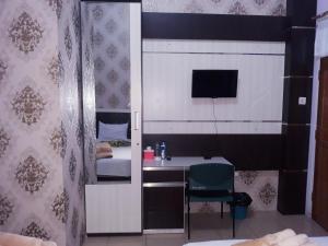 PadangpanjangTrivadoh Syariah Hotel的小房间设有床、水槽和书桌