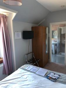 因弗内斯Drumdale Bed and Breakfast的卧室配有一张床,墙上配有电视。