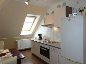 克吕茨Ferienwohnung Sommerwind的厨房配有白色冰箱和桌子