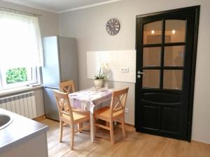 什奇特诺Leśny Apartament的厨房配有桌椅和黑色的门