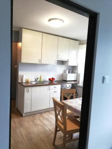 什奇特诺Leśny Apartament的厨房配有白色橱柜、桌子和用餐室。
